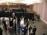 Trade show with room divided in three, center with bleacher seating