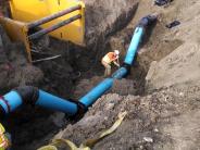 Lowering and re-routing a water main for installation of a larger storm main.