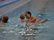 Instructor working with a boy in swim class