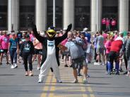 Runners mill about as they wait for the race to begin, including the penguin mascot.