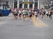 Runners make their way down the street as the race begins. 