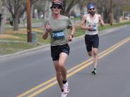 Two runners are shown as they make their way to the finish line