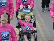 A small child being pushed in a stroller is in the race