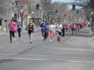 Hundreds of runners are shown making their way down the street