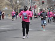 One runner is shown in the foreground with many other runners in the background