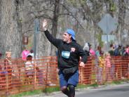 One runner waves to the crowd as he gets close to the finish line