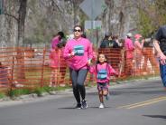 A parent and child are running towards the finish line