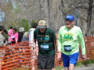 Two older runners are shown making their way towards the finish line