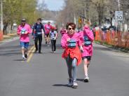 Many runners are shown in the stretch before reaching the finish line, including an older runner 