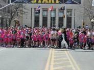 Runners lined up at the start of the race, including the penguin mascot 