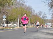 A few runners are shown making their way down the street 
