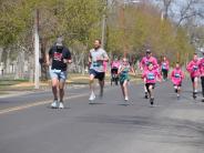 Many runners are shown making their way down the street 
