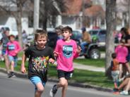 Several children are shown running down the street