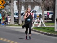 One female runner is shown running down the street