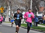 Many runners are shown running down the street