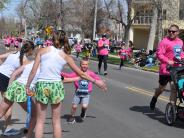 A young child receives high-fives as he runs in the race