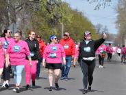 Many runners are shown walking down the street, one of which is taking a selfie