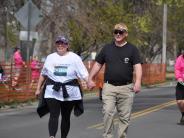 Two runners are shown walking hand in hand in the race