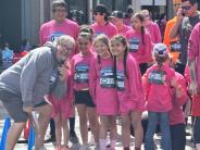 Several children in race t-shirts smile for the camera at the start line.