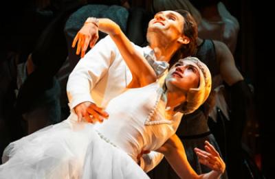 Male dancer with female dancer in front of him wearing white in a smooth pose