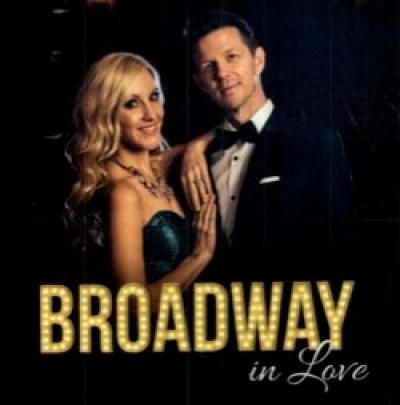 Blonde lady and Dark hair male with BROADWAY in love written on the bottom