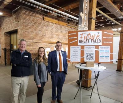 3 members of the City's Planning and Community Development Department standing beside a Growth Policy poster