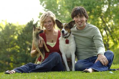 Couple with two dogs sitting in a park